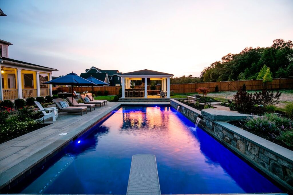 a pool at dusk with trees in the background
