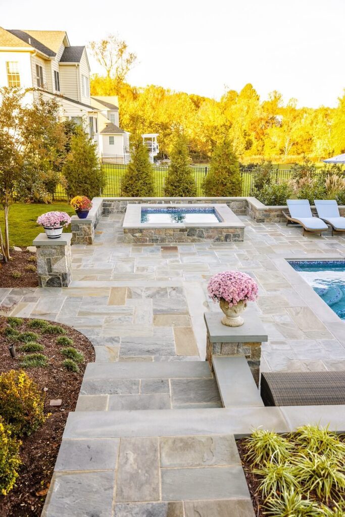 Backyard with Raised Stone Spa and Hardscaping Flagstone Patio with Stone Steps Stone Retaining Walls and Stone Piers