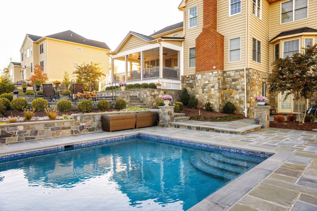 Backyard with pool and hardscaping Custom Covered Deck Flagstone Patio with Stone Steps Stone Retaining Walls