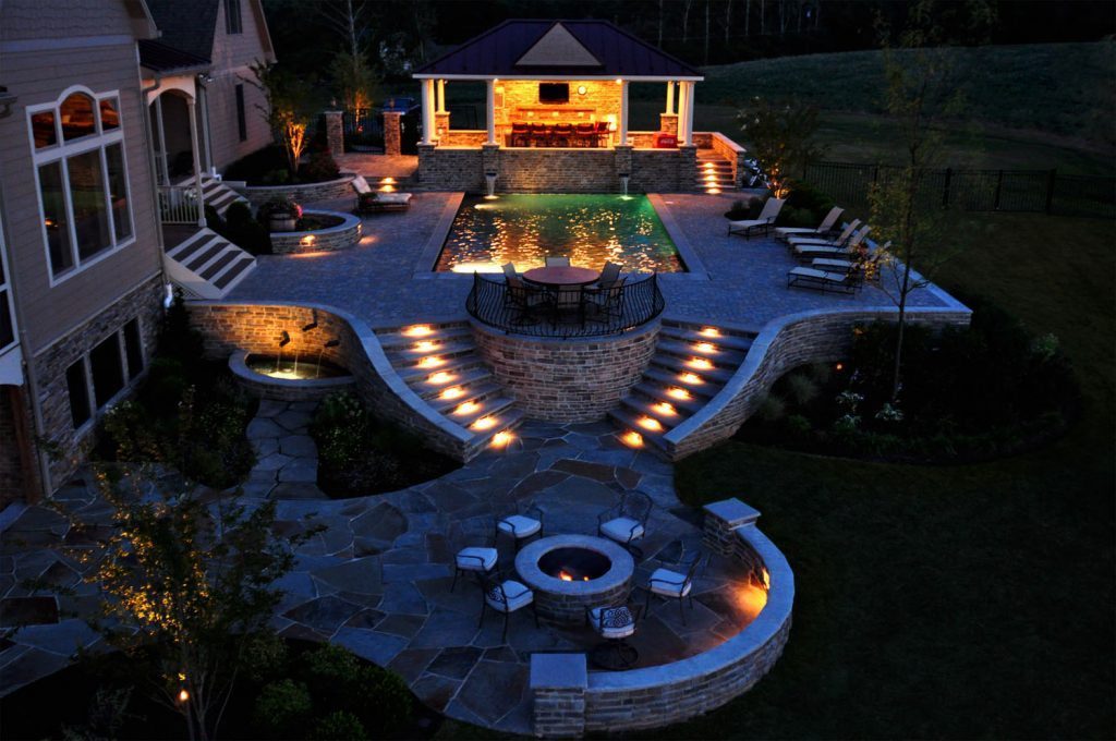 Swimming Pool and Custom Water Feature Paver Pool Deck and Patio Stone Fire Pit with Stone Seat Walls and Piers Flagstone Patio Low Voltage Lighting