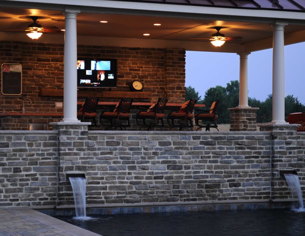 Custom Swimming Pool with Elevated Pavilion Custom Outdoor Bar Stone Walls and Paver Pool Deck