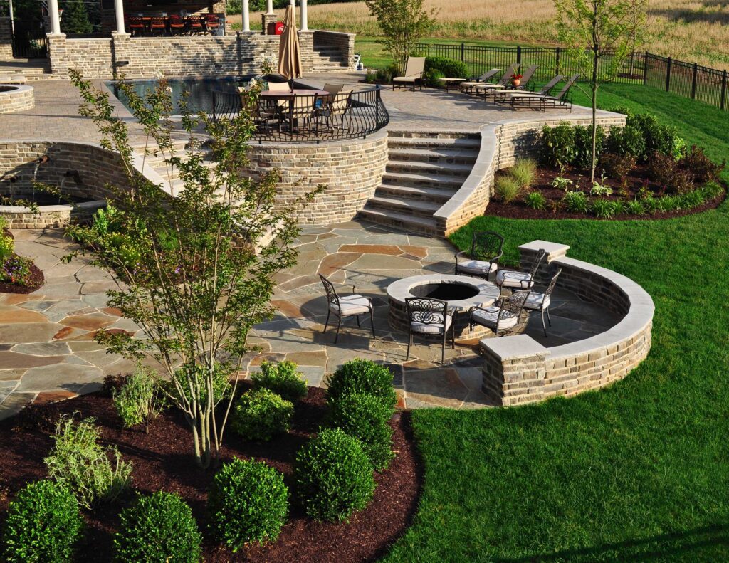 Flagstone Patio with Stone Fire Pit Stone Retaining Walls Stone Seat Walls with Piers Swimming Pool and Water Feature