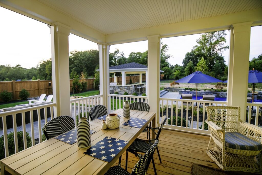 covered deck overlooking swimming pool in rear yard