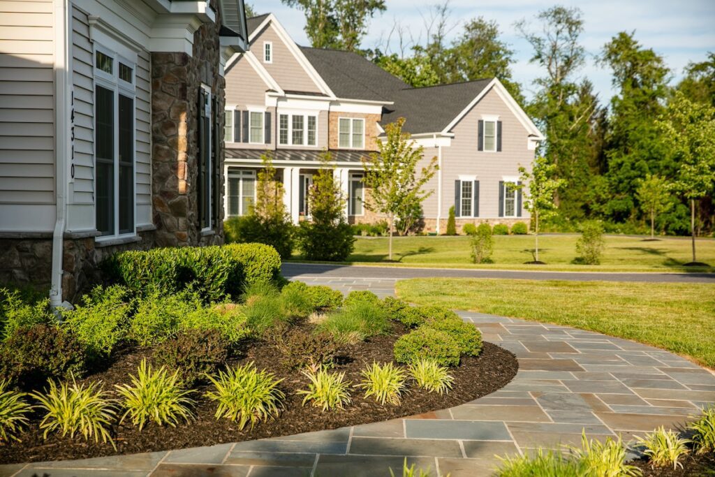 landscape plantings beds in front of house with a flagstone walkway