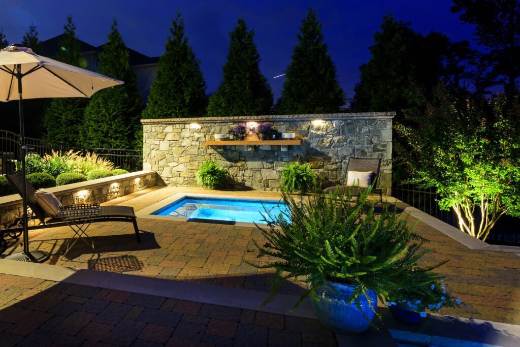 inground spa with stone privacy wall