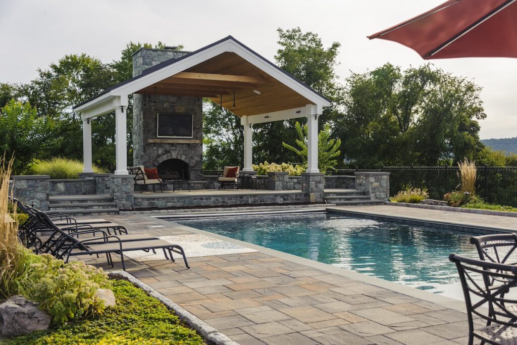 pool pavilion with stone fireplace and swimming pool