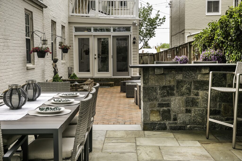 Brick and Flagstone Patios in backyard with Bar Seating and Water Feature