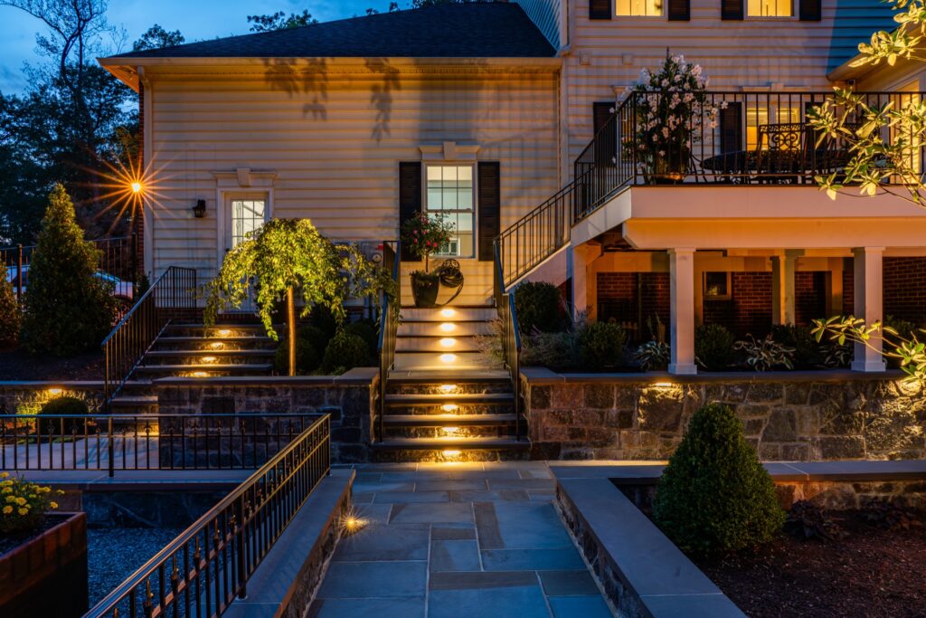 Custom Composite Deck with Steps and Iron Railings Stone Retaining Walls with Steps Step Riser Lighting Landscape Plantings Flagstone Walkways