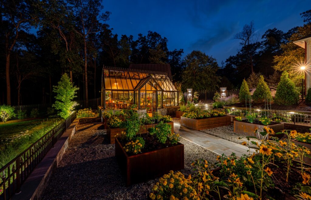 Backyard garden project with Hartley Botanic Glass Greenhouse and raised Corten steel garden planters. Landscape Plantings Low Voltage Lighting Flagstone Walkway with Stone Steps Stone Entry Piers with Wrought Iron Gates