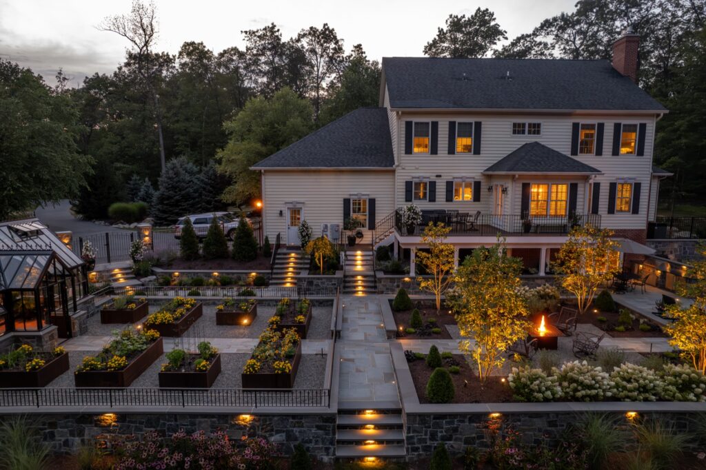 Backyard masterplan project with glass greenhouse and raised Corten steel garden planters. Stone Walls and Steps Landscape Plantings Low Voltage Lighting Composite Deck with Steps Fire Table