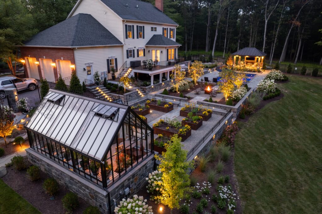 Backyard masterplan project with Hartley Botanic Glass Greenhouse and raised Corten steel garden planters. Stone Walls and Steps Landscape Plantings Low Voltage Lighting Pavilion