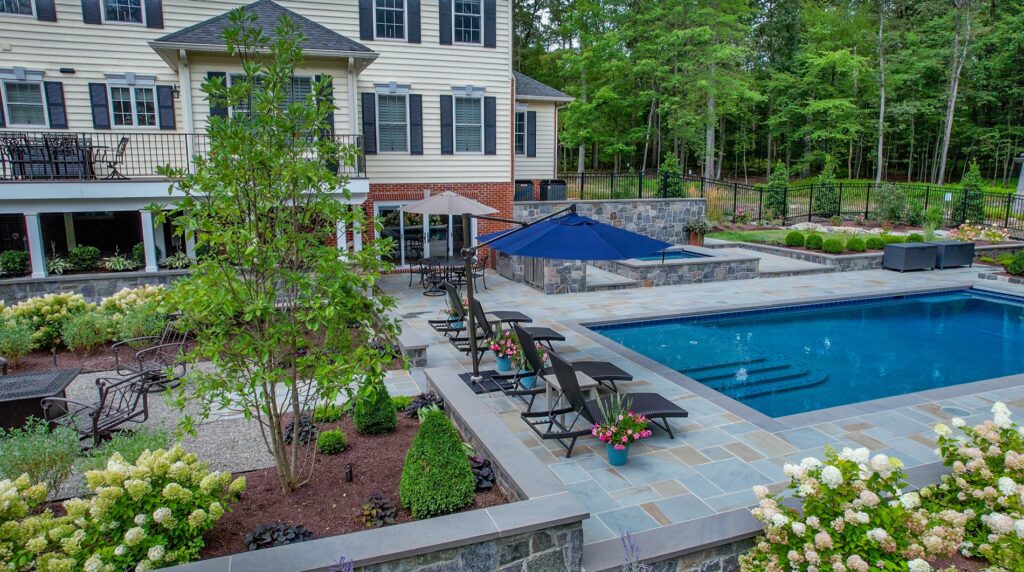 Backyard with custom swimming pool and spa Flagstone Patios and Walkways with Stone Steps Stone Retaining Walls Landscape Plantings Decorative Gravel Patio