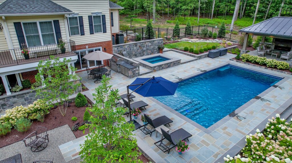 Backyard with custom swimming pool and spa Flagstone Patios and Walkways with Stone Steps Stone Retaining Walls Landscape Plantings Decorative Gravel Patio Custom Pavilion