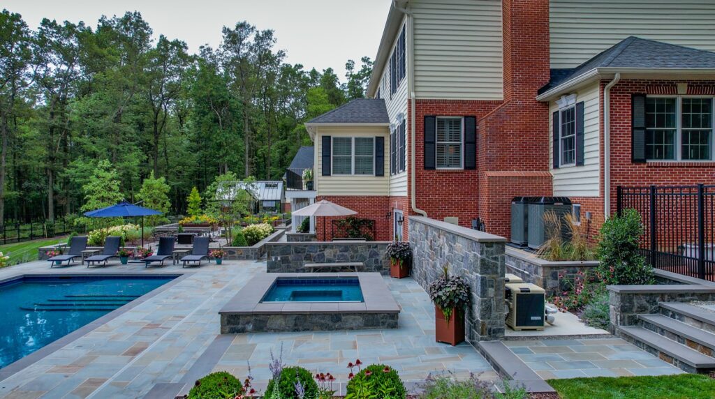 Backyard with custom swimming pool and spa Flagstone Patios and Walkways with Stone Steps Stone Retaining Walls Landscape Plantings