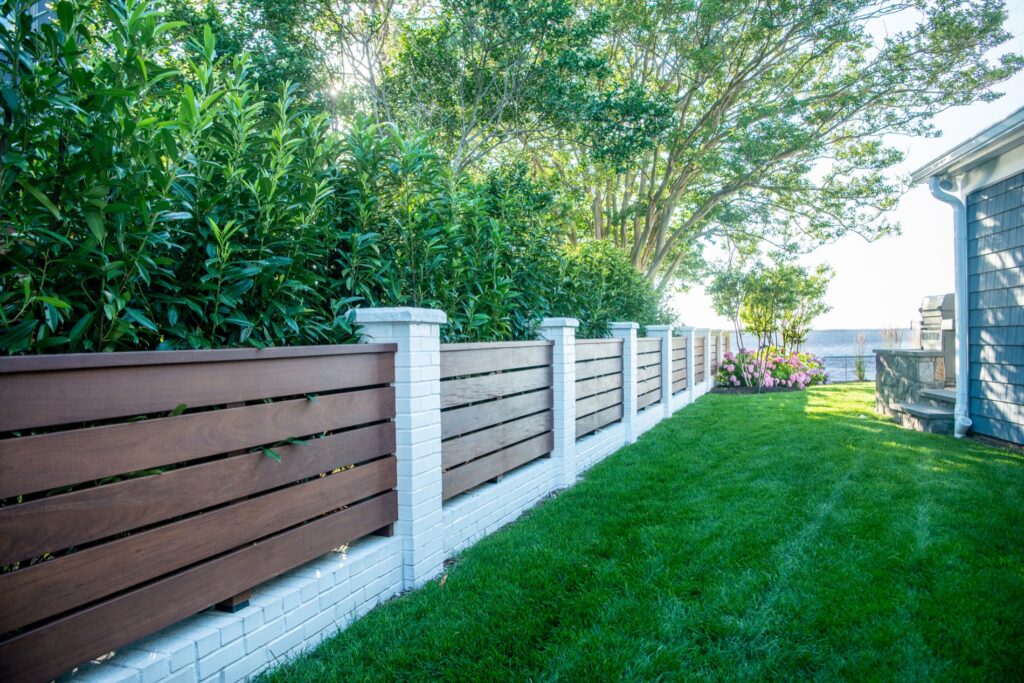 custom fence with brick piers and knee wall