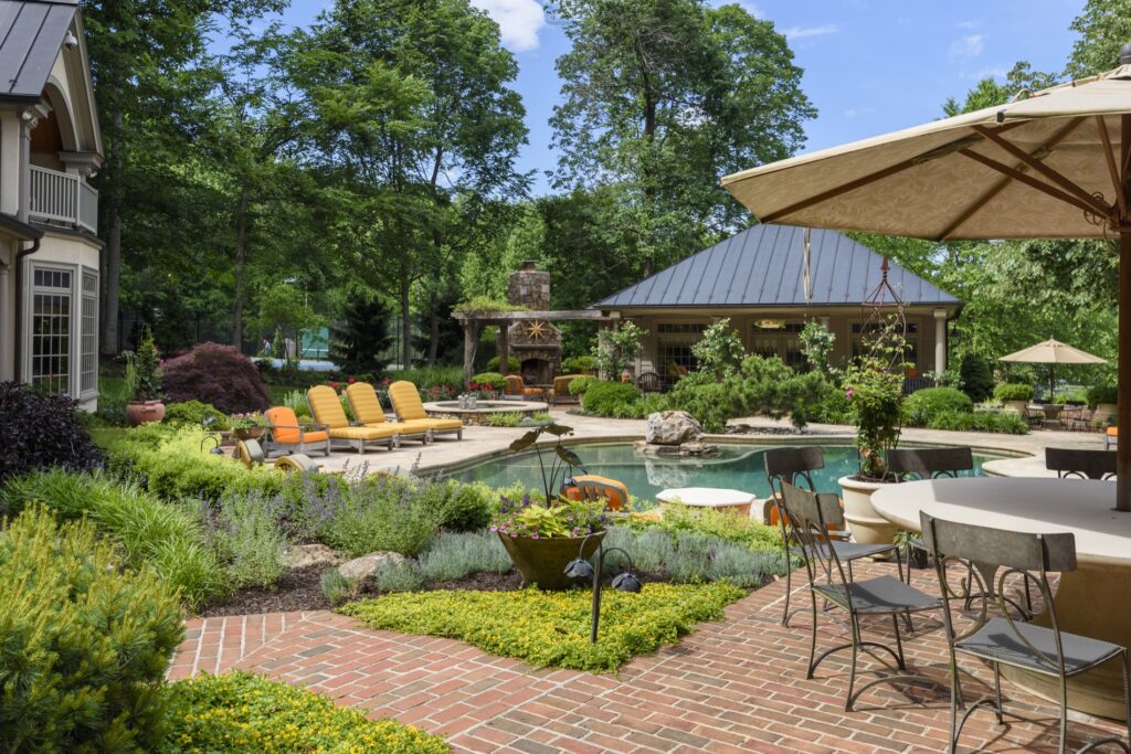 brick patio with swimming pool and landscape plantings