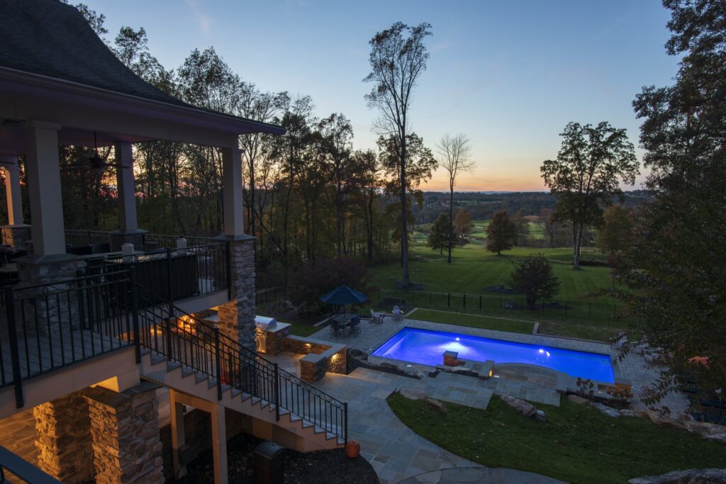 Swimming pool in backyard with paver pool deck flagstone walkway and stone steps low voltage lighting