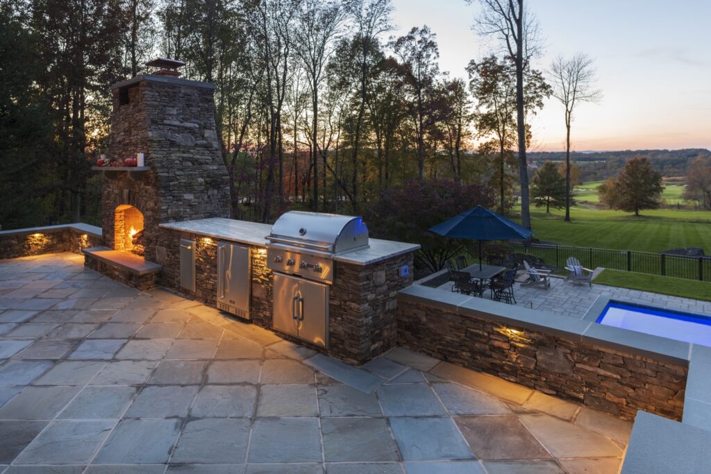 Outdoor Stone woodburning fireplace Outdoor Stone Kitchen with Granite Countertop Stone Seat Walls Flagstone Patio