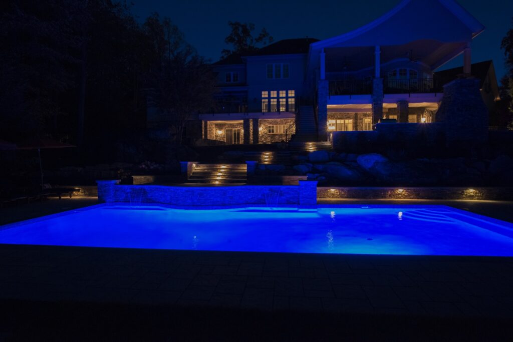 Swimming Pool and Night with blue pool lights Stone walls and steps with LV lighting