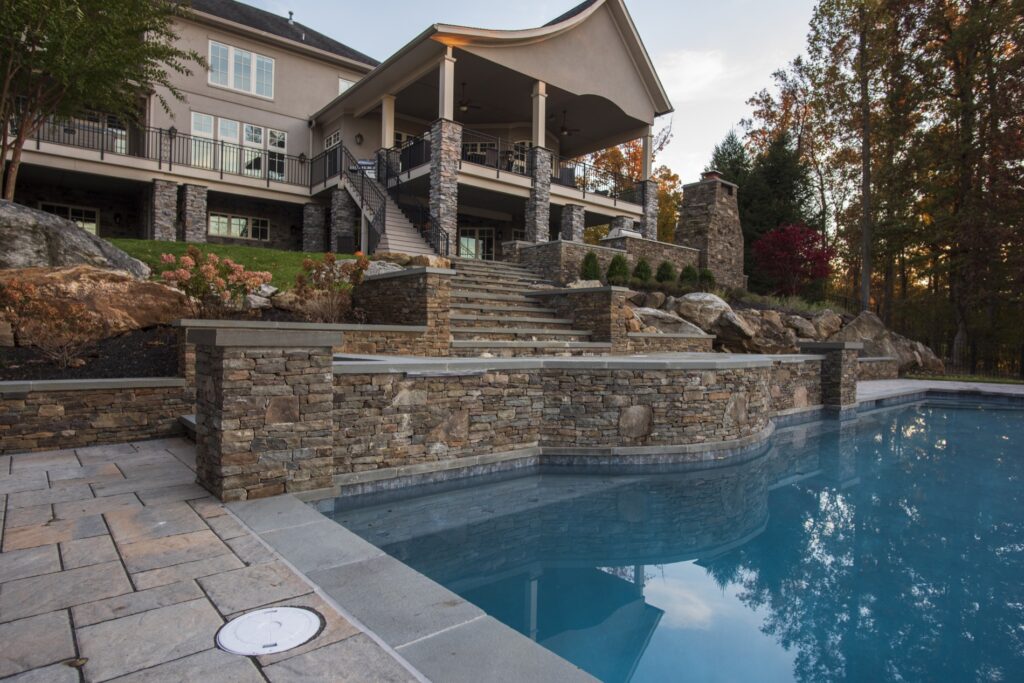 Swimming pool in backyard with paver pool deck flagstone walkway and stone steps Landscape Plantings